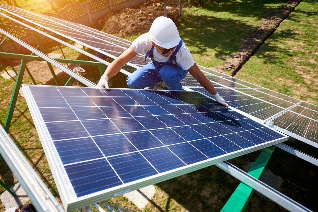 Professional Worker Installing Solar Panels On The Green Metal Construction